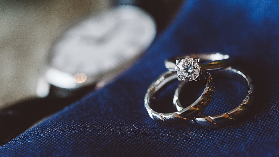 Alianzas de boda sobre una tela azul, relacionadas con el certificado de matrimonio