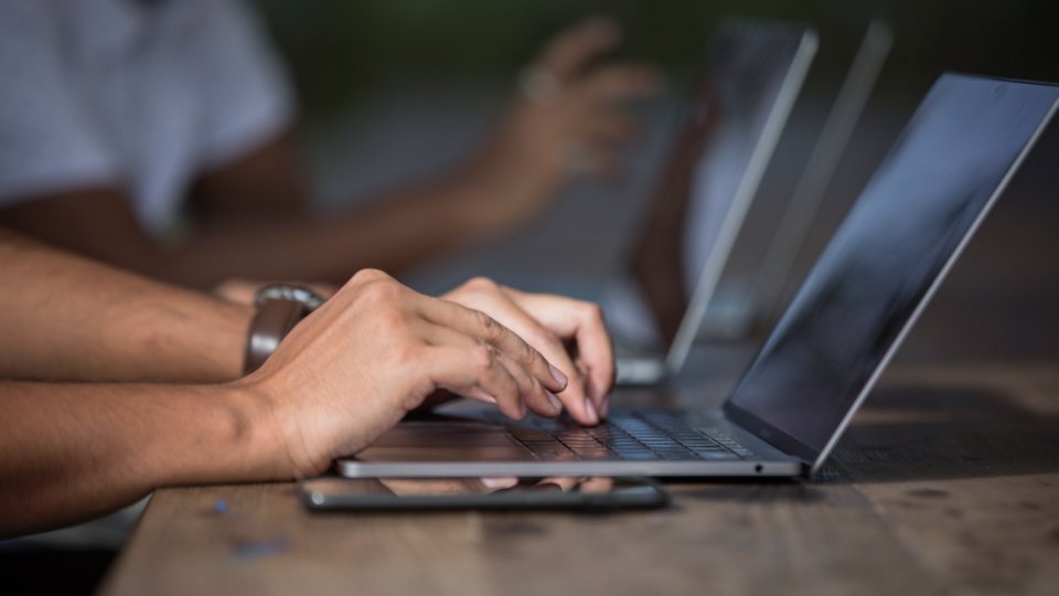 Manos escribiendo en un portátil para firmar con AutoFirma