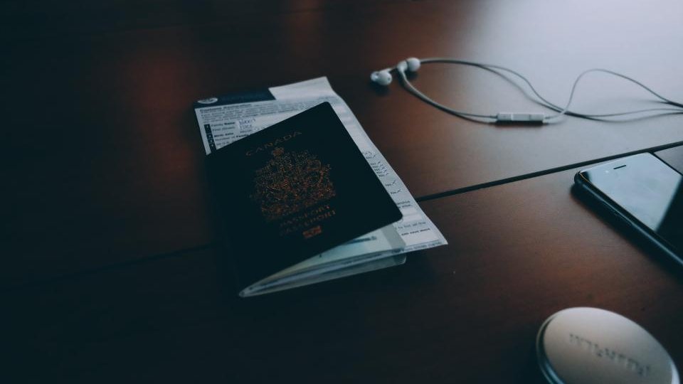 Pasaporte sobre una mesa junto a unos auriculares antes de renovar el pasaporte